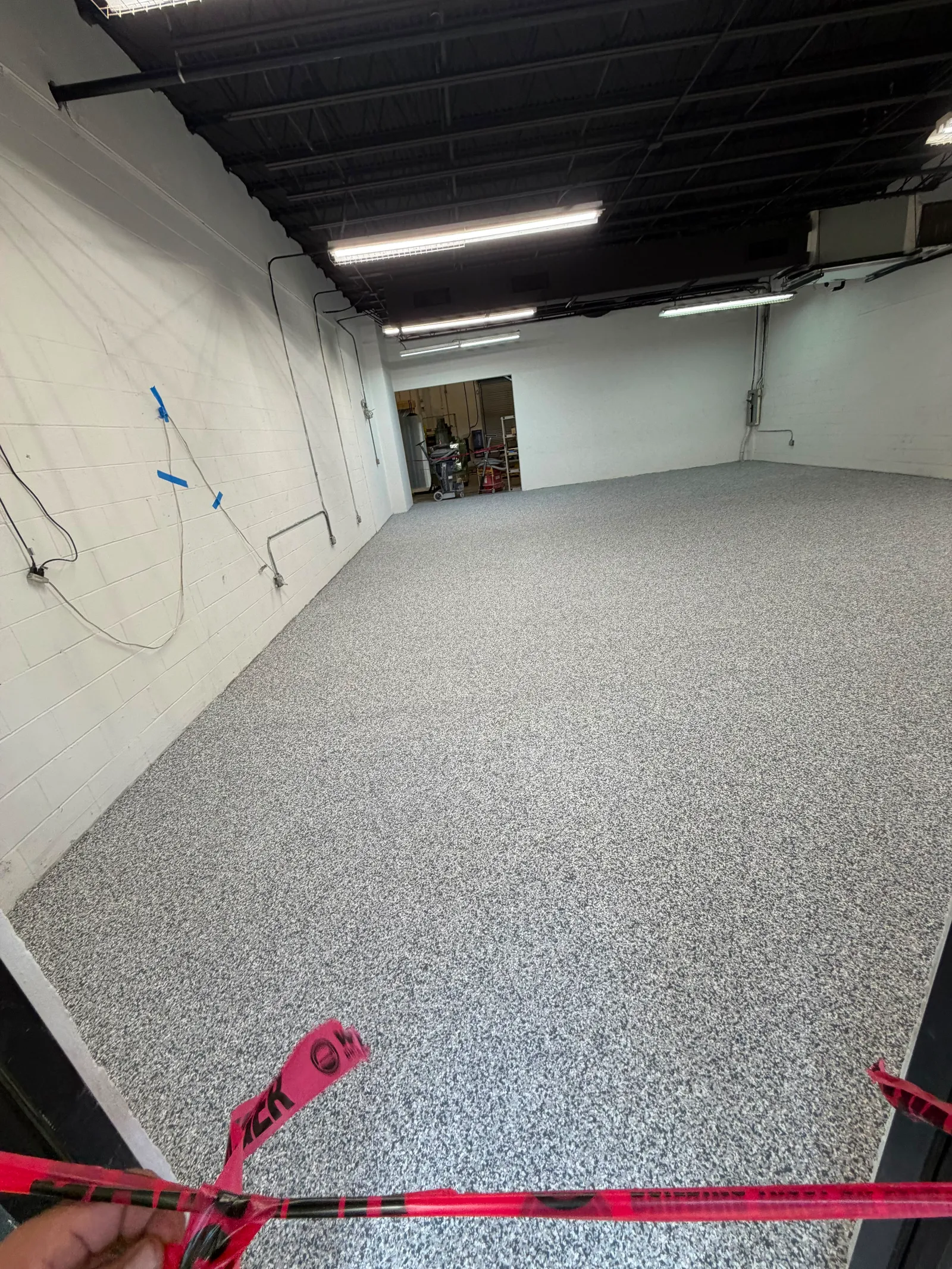 The same warehouse floor after a grey decorative flake coating system was installed