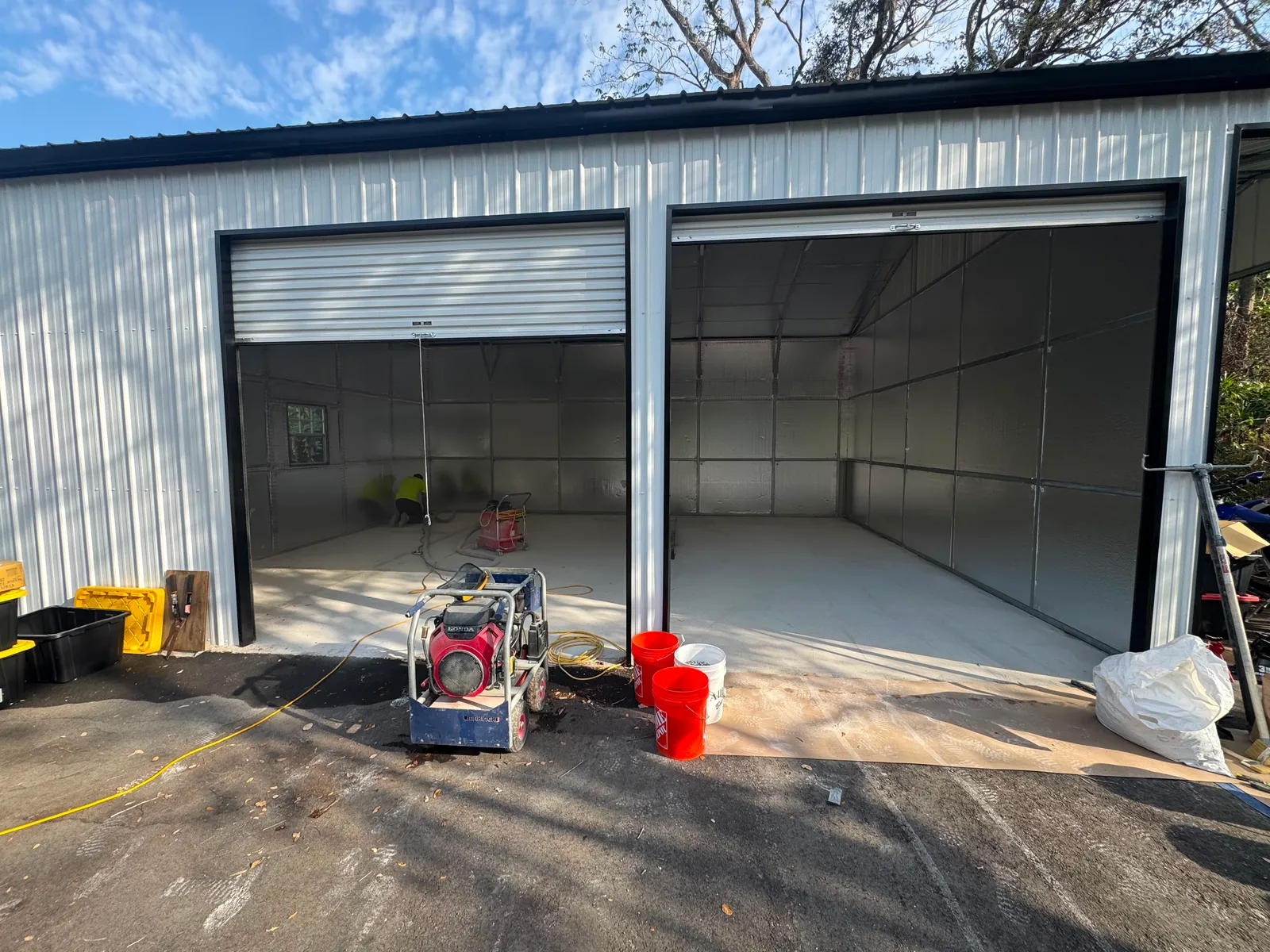 Metal warehouse building with a bare concrete apron staged for floor coating