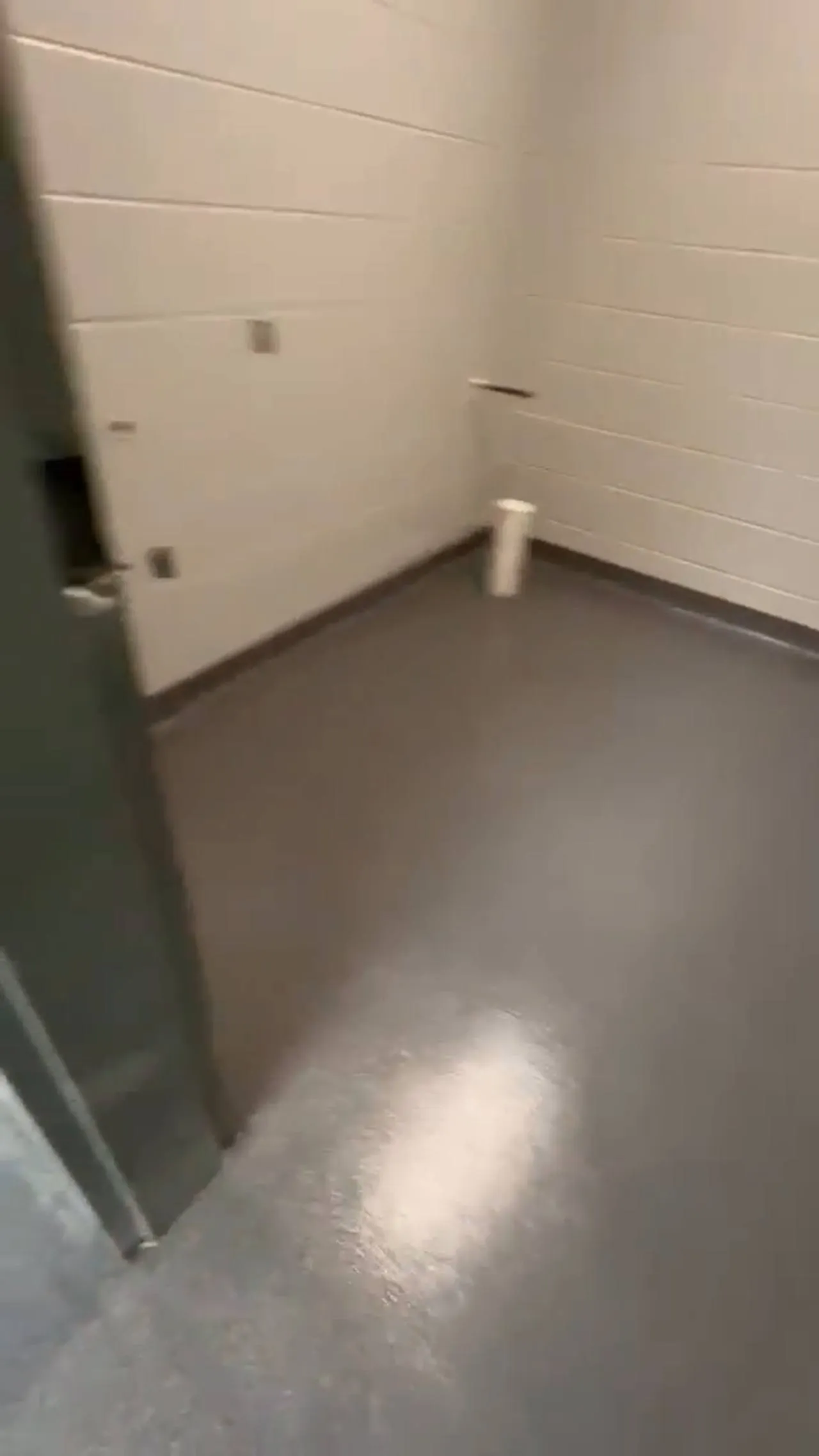 Grey, black and white decorative flake floor with a clear gloss topcoat in a block-walled commercial room