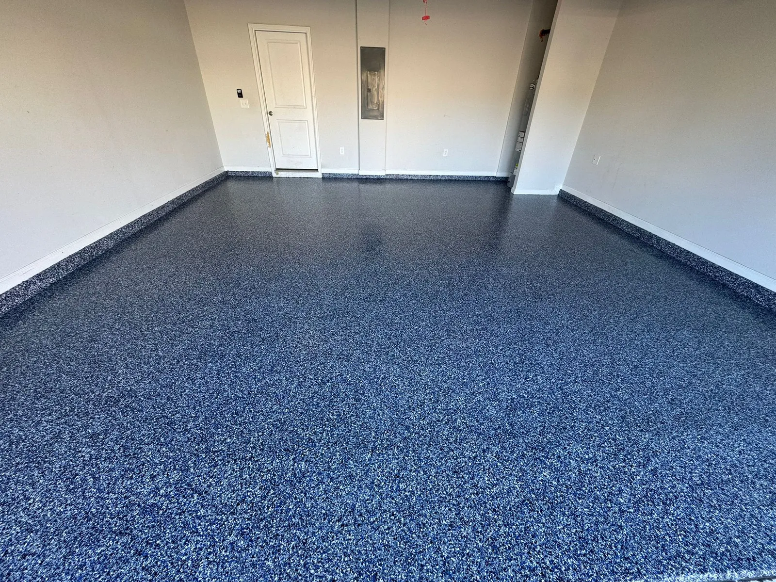 Blue decorative flake flooring with a clean cove edge in a residential garage