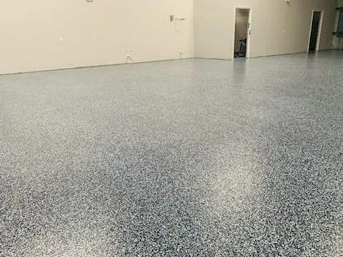 Grey decorative flake flooring extending down a bright commercial corridor in an office building