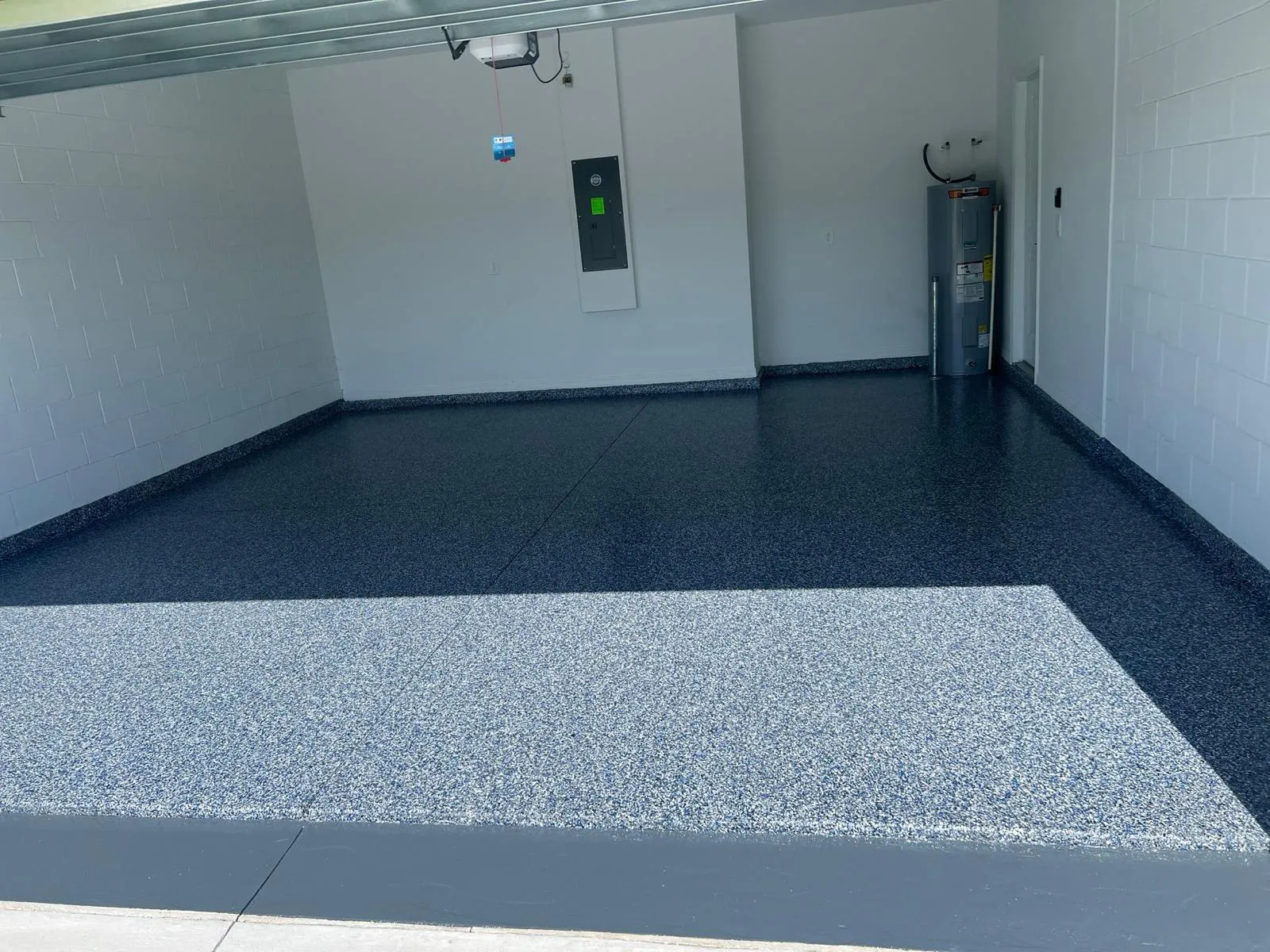Light decorative flake floor bordered by a solid grey coating in a commercial room