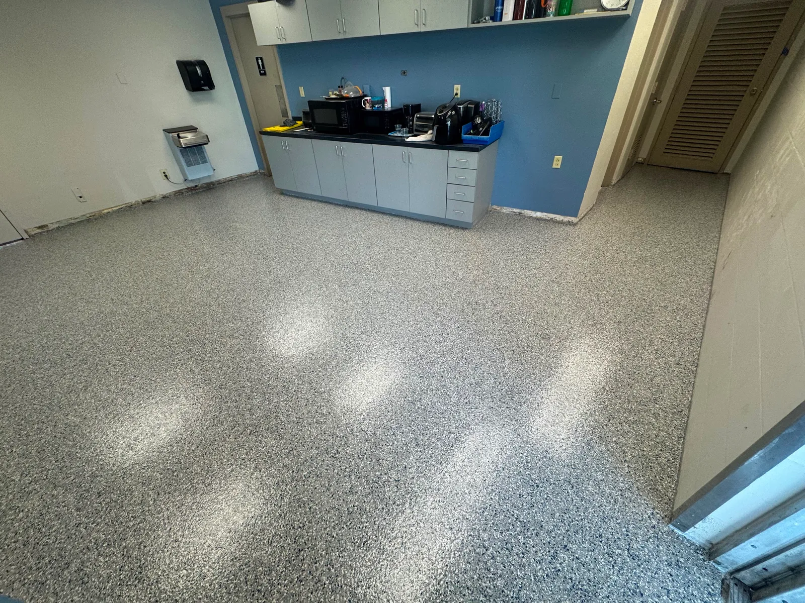 Decorative flake floor reflecting ceiling lights beside a laboratory workstation