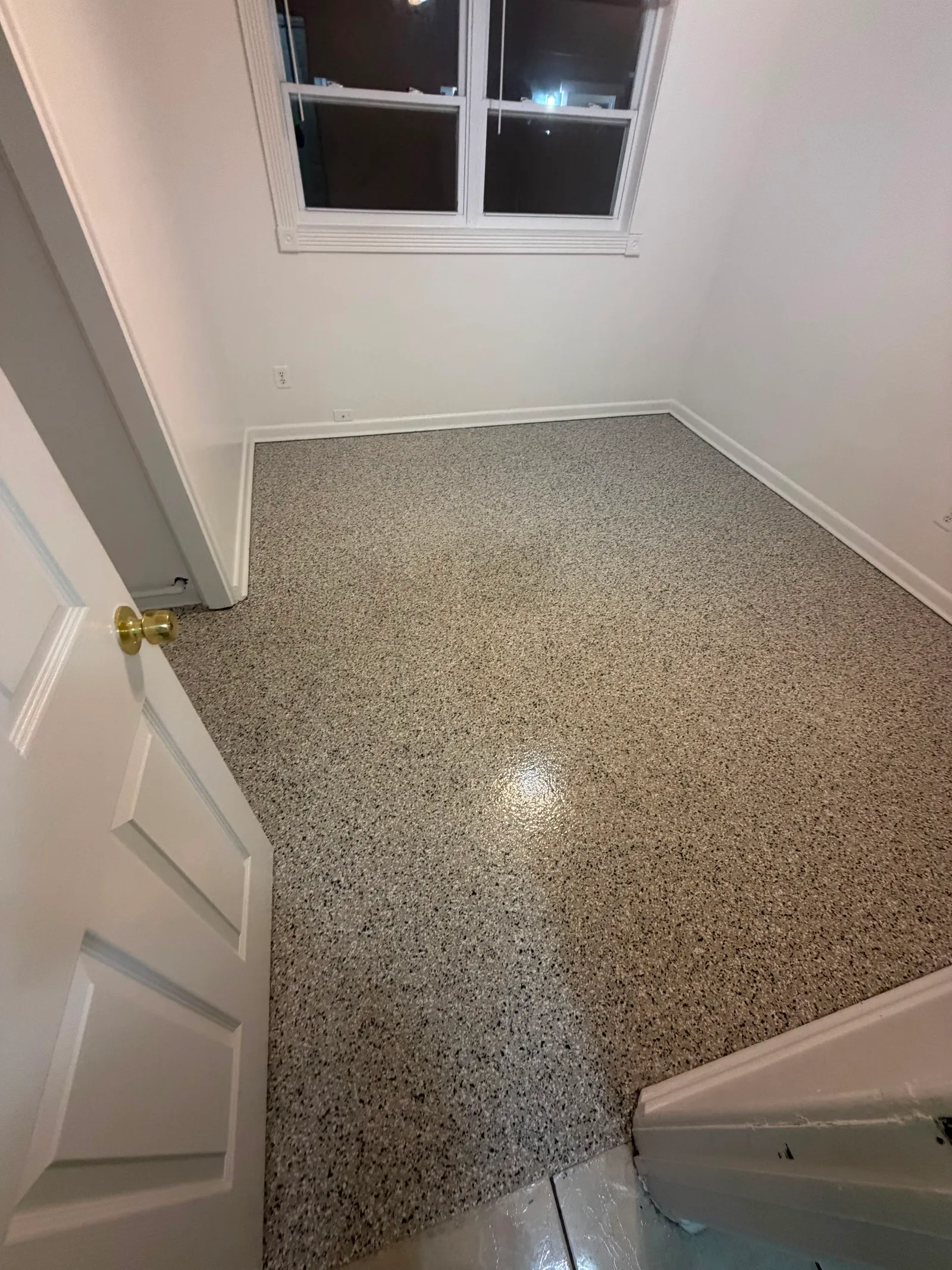 Tan and brown decorative flake floor with a clear gloss topcoat in a residential entry