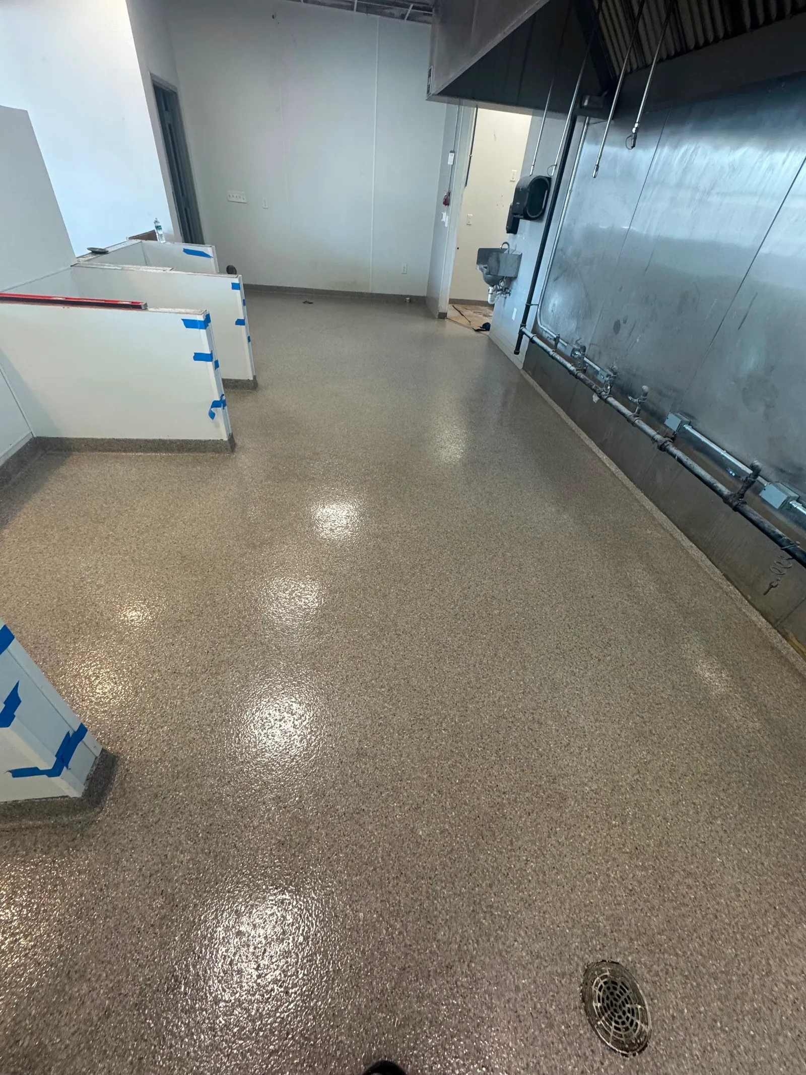 Grey decorative flake floor surrounding heavy machinery on a manufacturing production floor