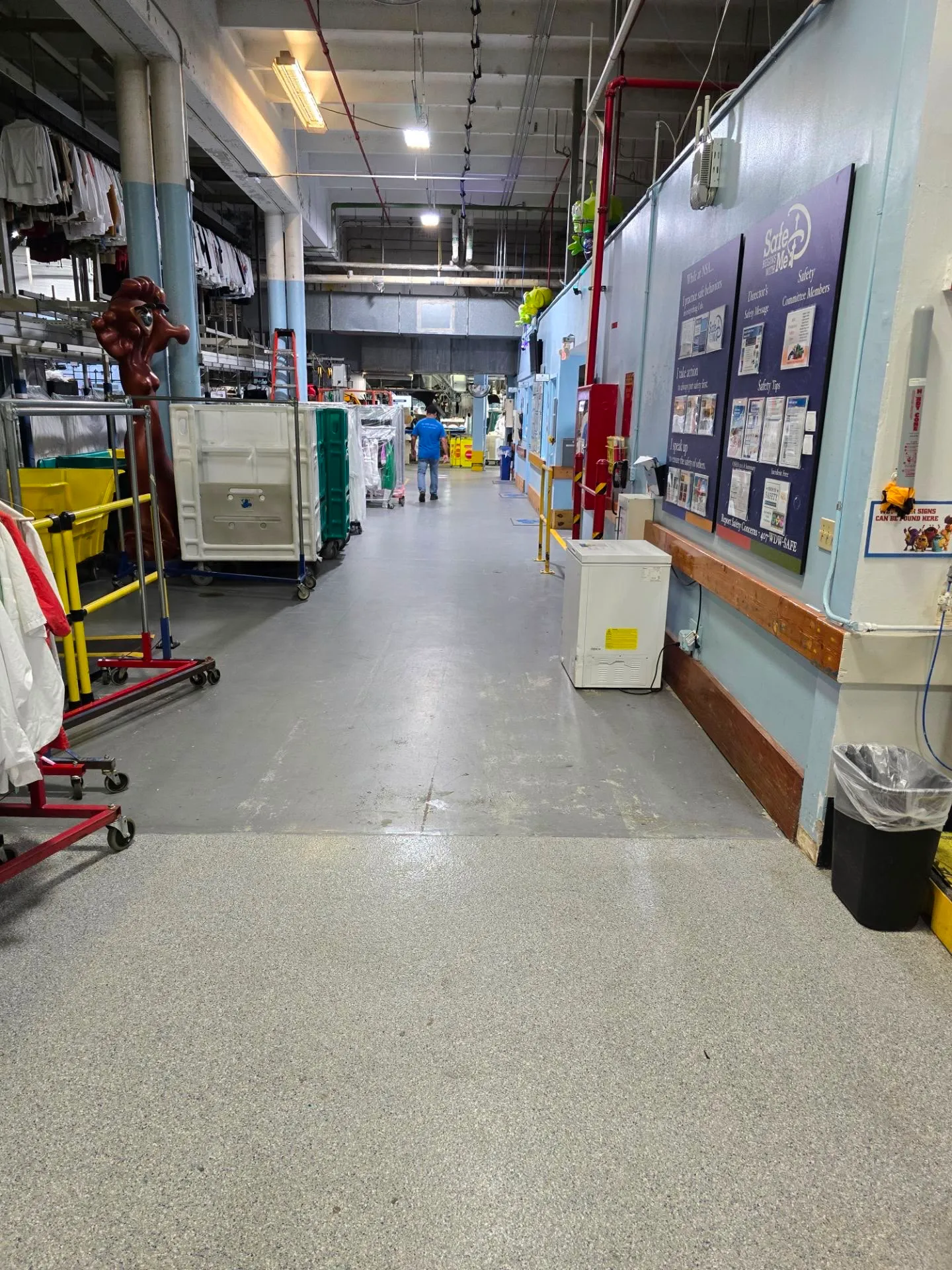 Sealed resinous floor down a working manufacturing aisle lined with production equipment