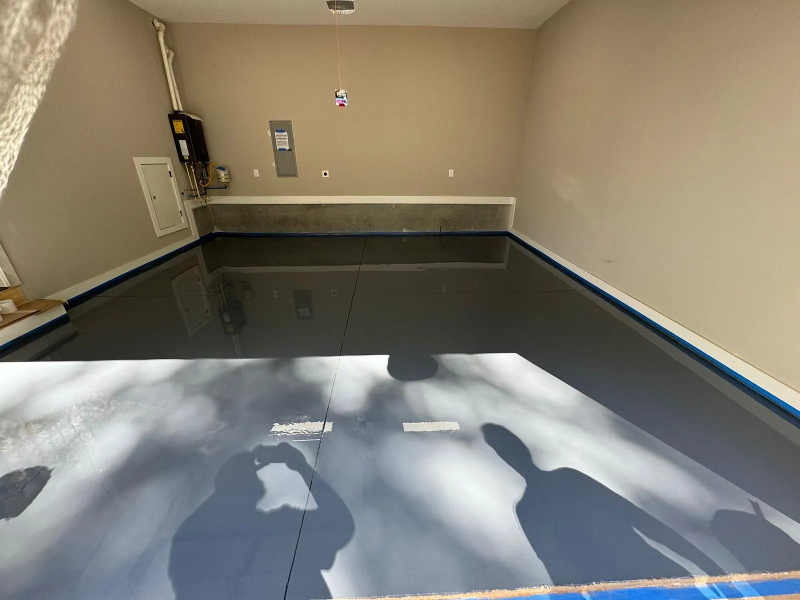 Dark charcoal high-gloss metallic coating with mirror reflections in a residential garage