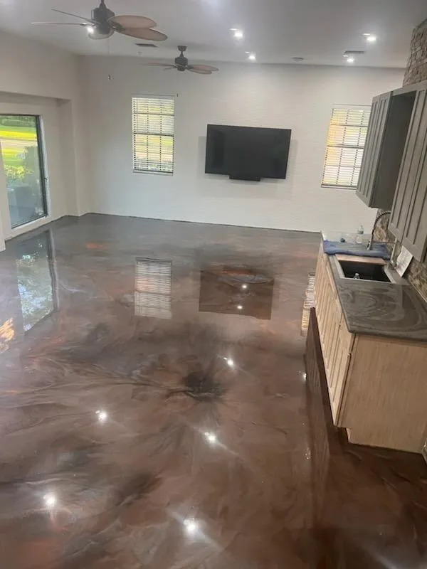Reflective copper metallic epoxy floor flowing through a residential kitchen and living area