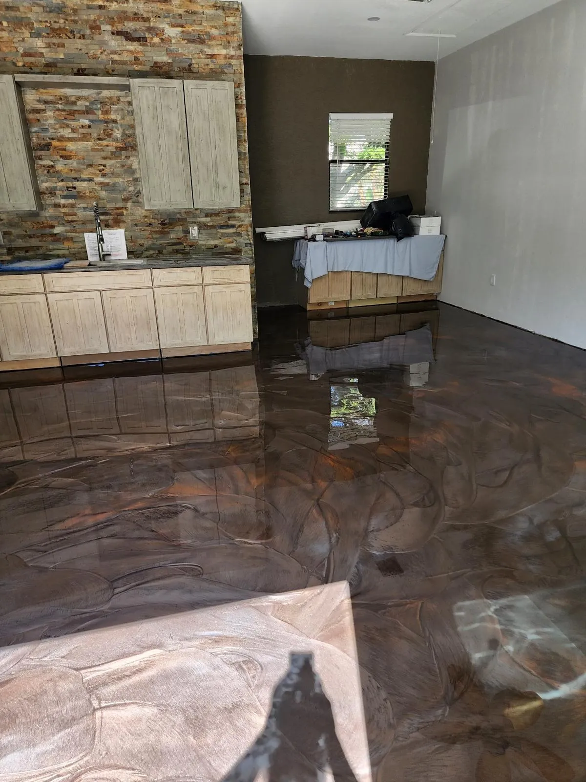 Rich copper metallic epoxy floor with a mirror-like reflection in a residential kitchen