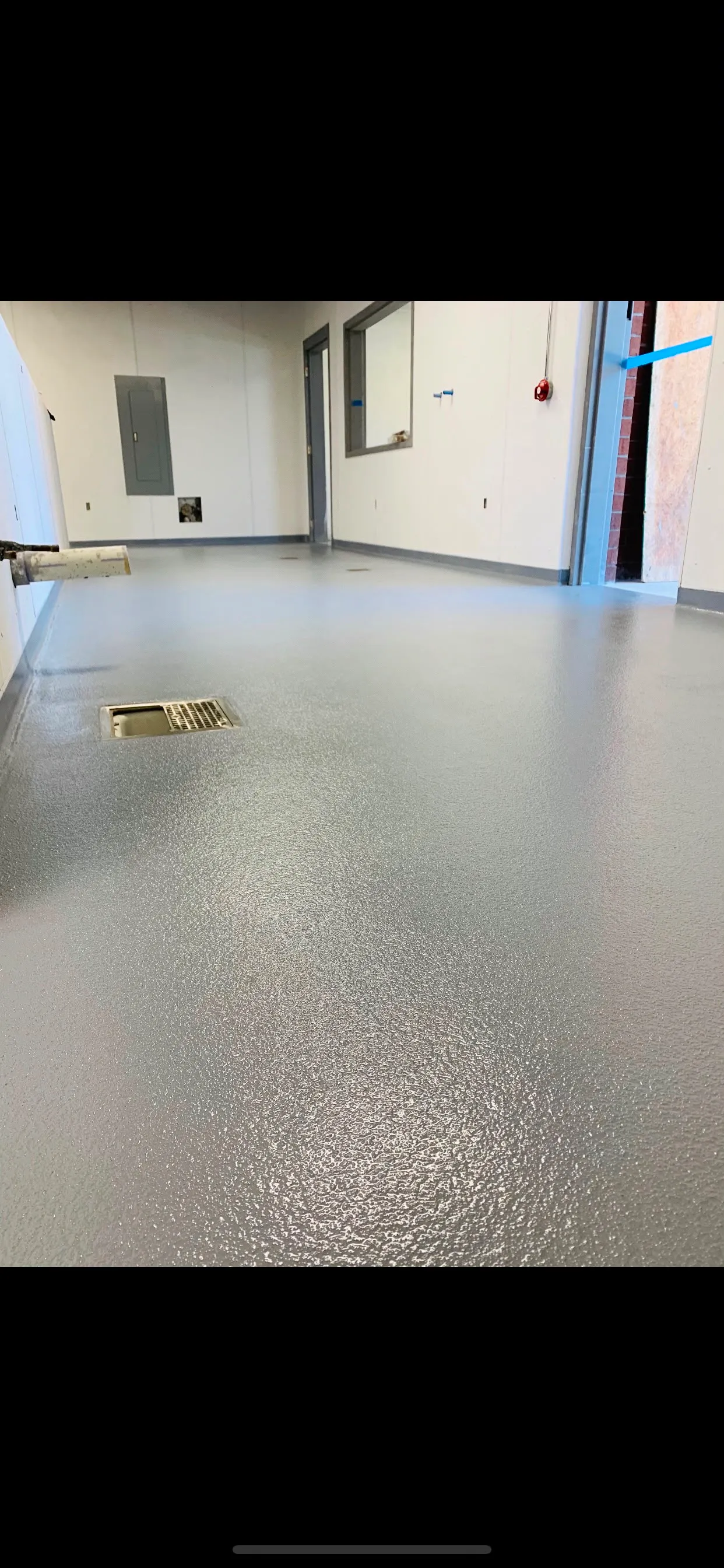 Textured quartz floor sloped to a central drain in a commercial wash-down area