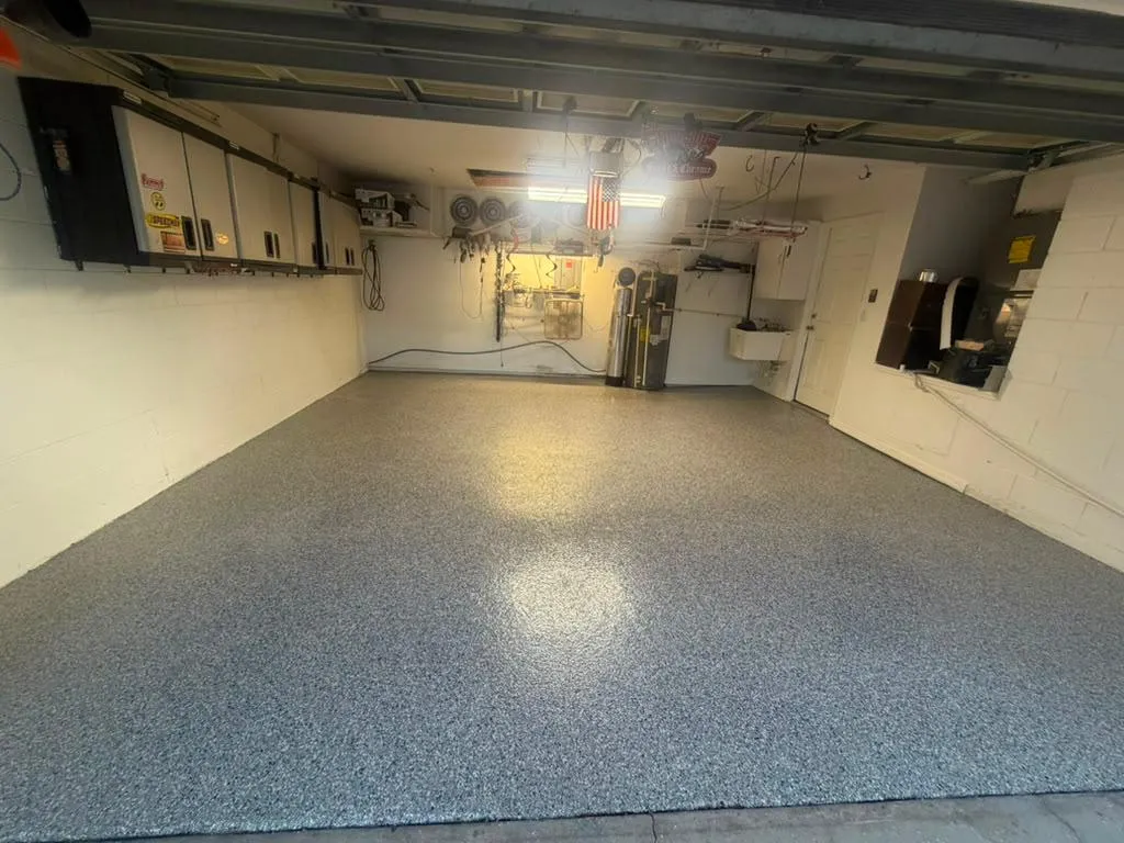 Finished two-car residential garage with a grey, blue and white decorative flake floor and a high-gloss topcoat