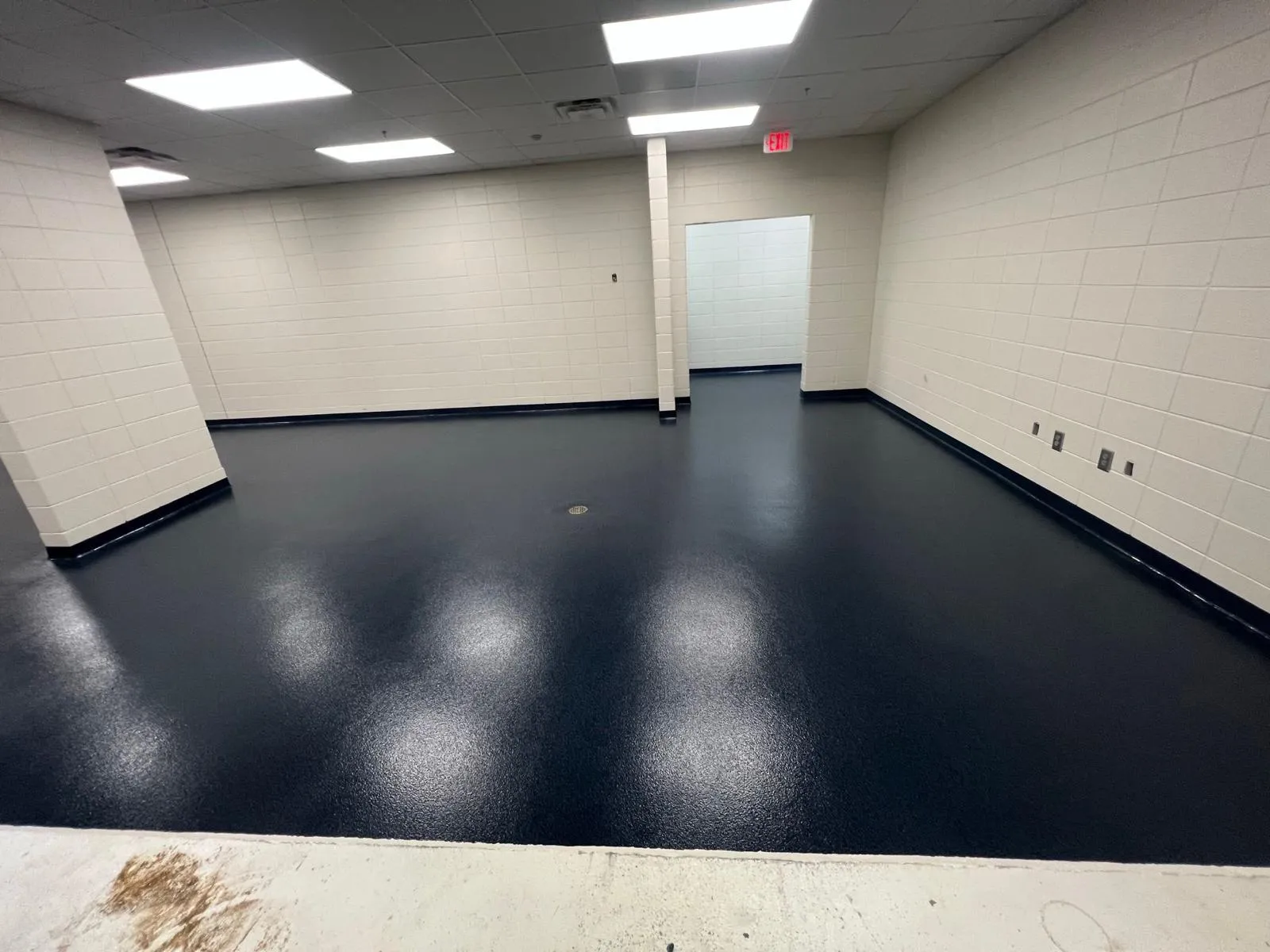 Dark slate resinous floor with a reflective finish in a commercial back-of-house room