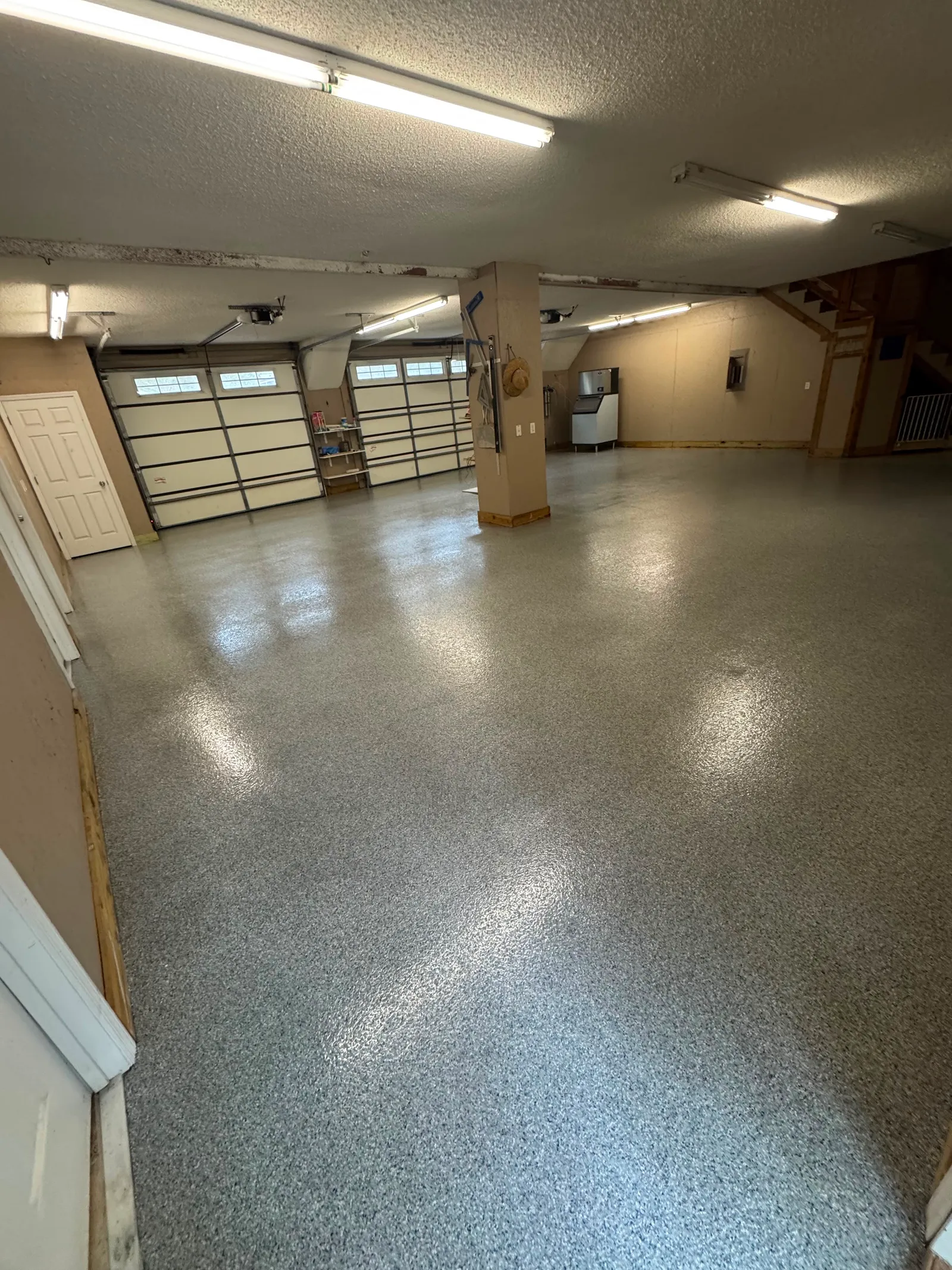 High-gloss grey resinous floor in a large open commercial service bay